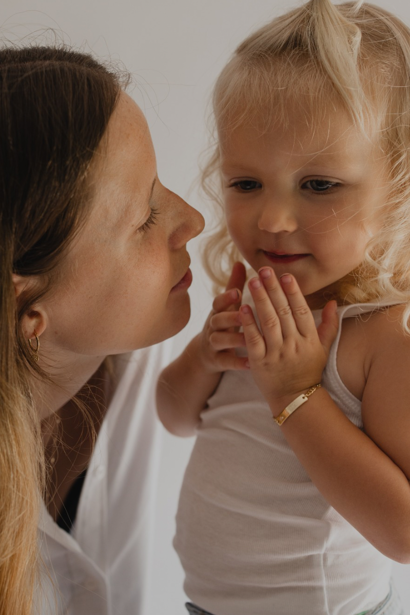 A child wearing the Bluebird Jewellery Pink Darling Bracelet gold, designed with a pink heart charm as a meaningful  bracelet and keepsake.