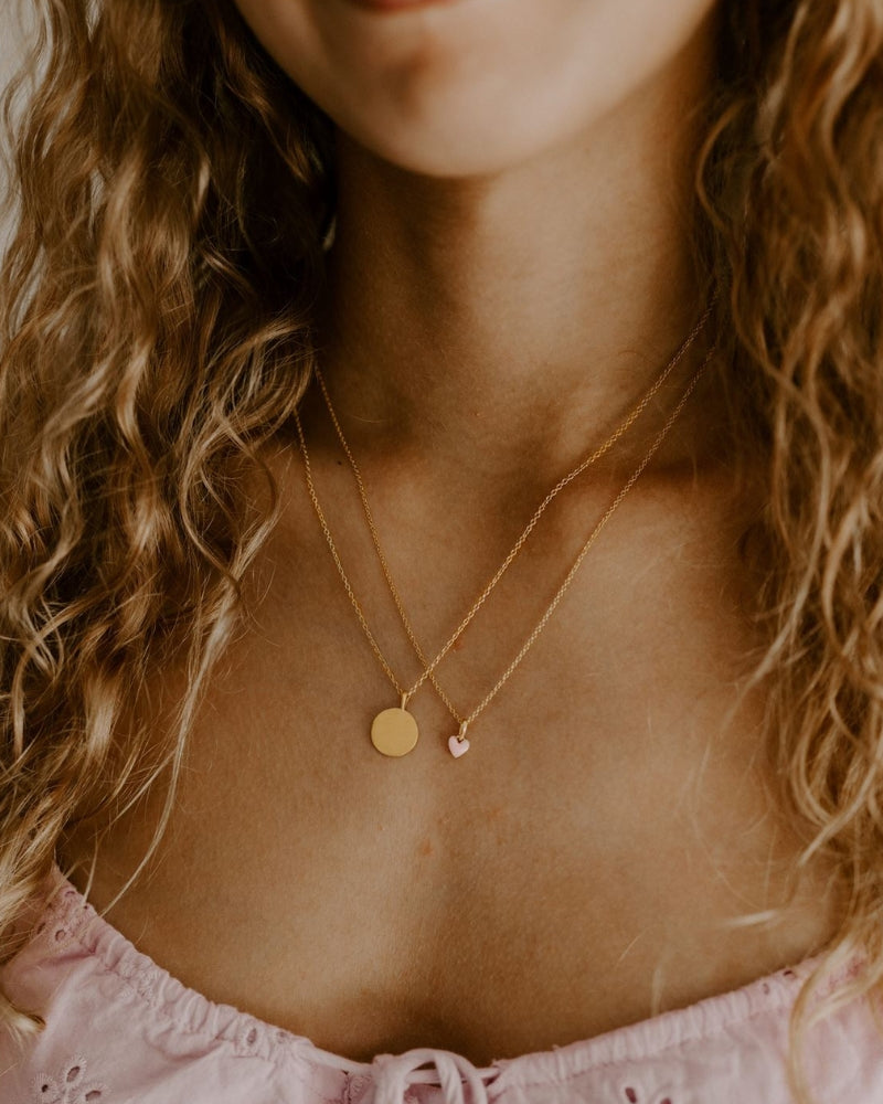 A teenager wears the Pink Petite Darling Necklace alongside the Petite Signature Necklace for a fine layered look.