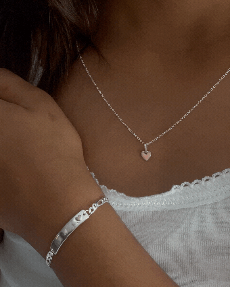 A close up video showing the Pink Petite Darling Necklace and Pink Darling Bracelet on a young girl.