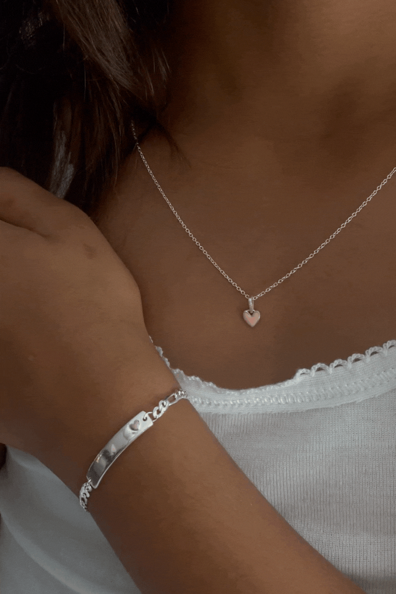 A close up video showing the Pink Petite Darling Necklace and Pink Darling Bracelet on a young girl.