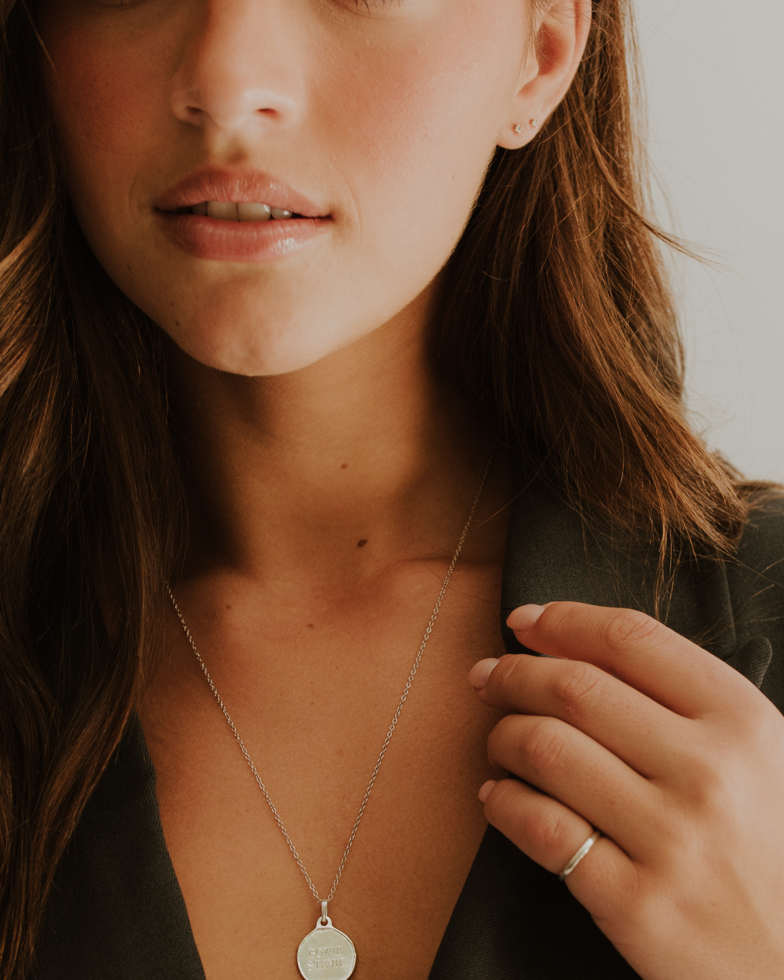 A woman is wearing an elegant silver band on her pinky finger.