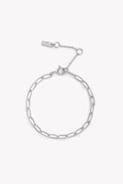A polished silver bracelet featuring a delicate chain design, displayed on a white background to highlight its craftsmanship.