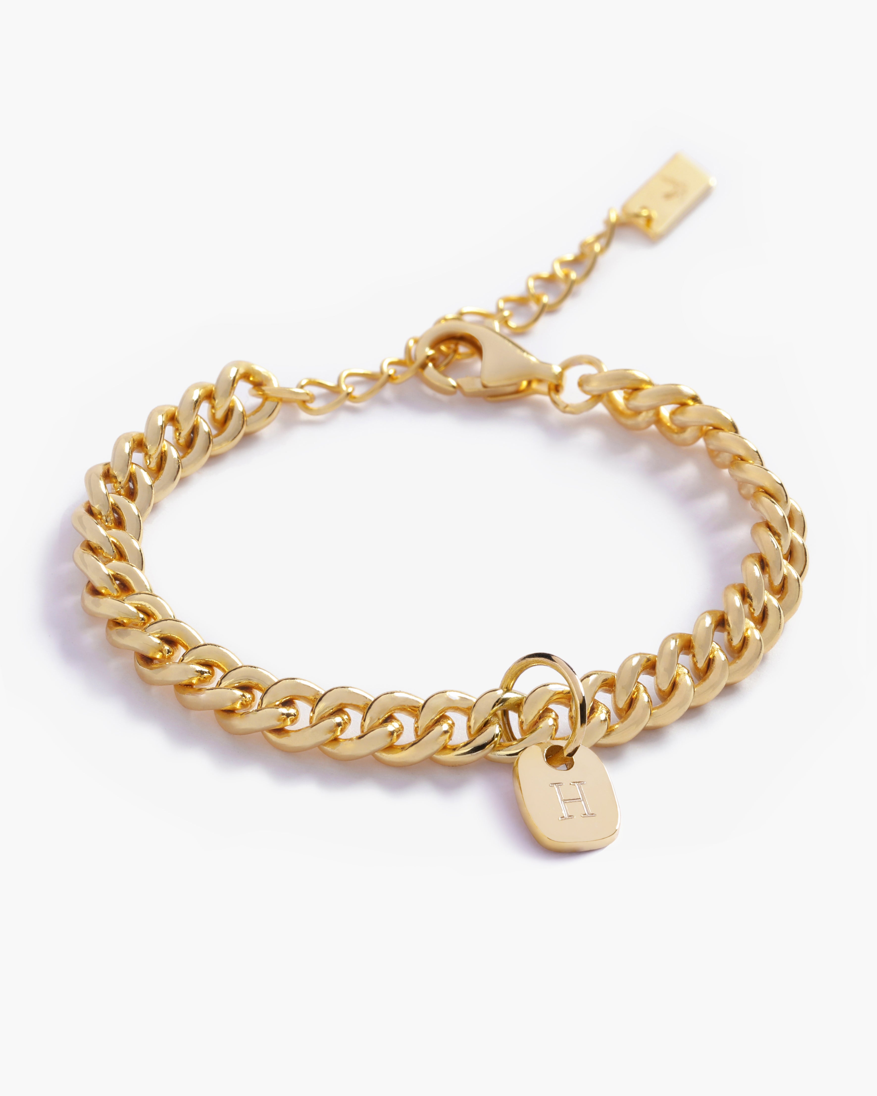 A close-up image showcasing the texture of a gold Cuban Link Chain and soild gold rectangular pendant, designed in elegant minimalist style by Bluebird Jewellery.