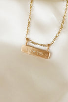 Engraved gold bar necklace with “I LOVE YOU” message, featuring figaro chain, a meaningful everyday keepsake.