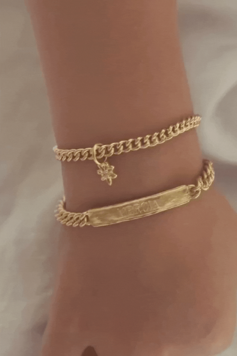 Bluebird Co's signature bracelet, daisy pendant, and cuban link in gold with engraving.