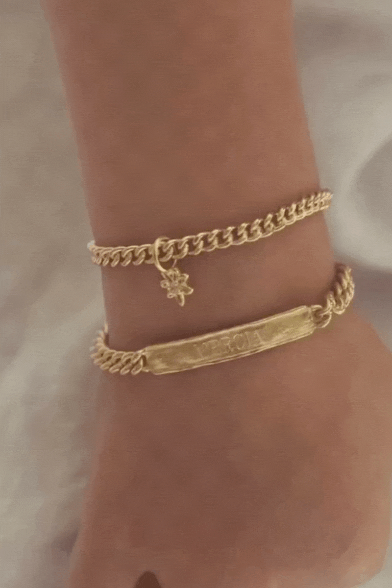 Bluebird Co's signature bracelet, daisy pendant, and cuban link in gold with engraving.