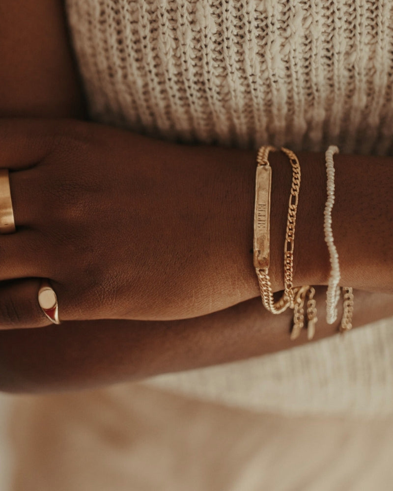 A close up of a Signature Bracelet with a name engraved on it by Bluebird Jewellery.