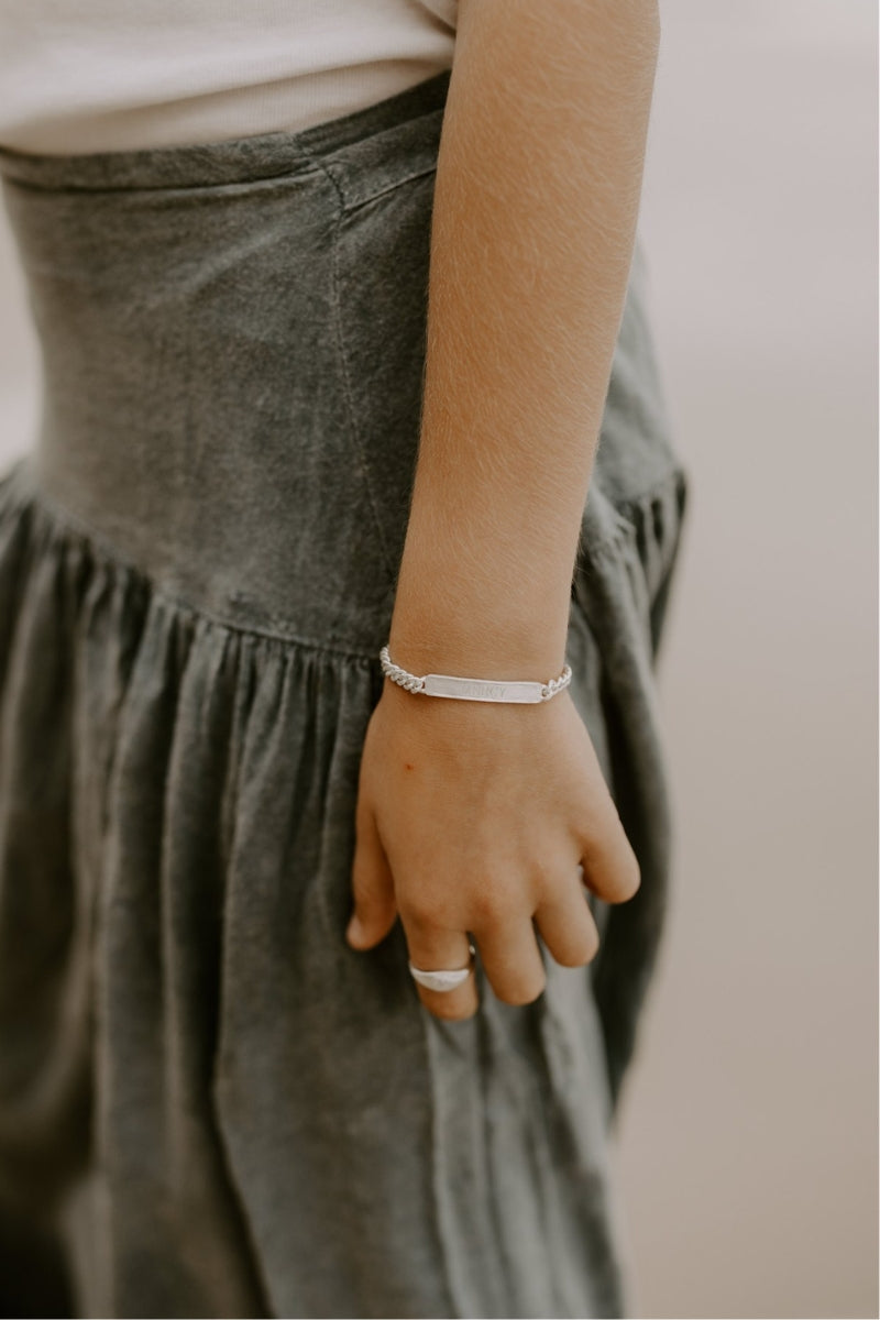 Child wearing silver engraved bracelet for everyday wear by Bluebird Jewellery.