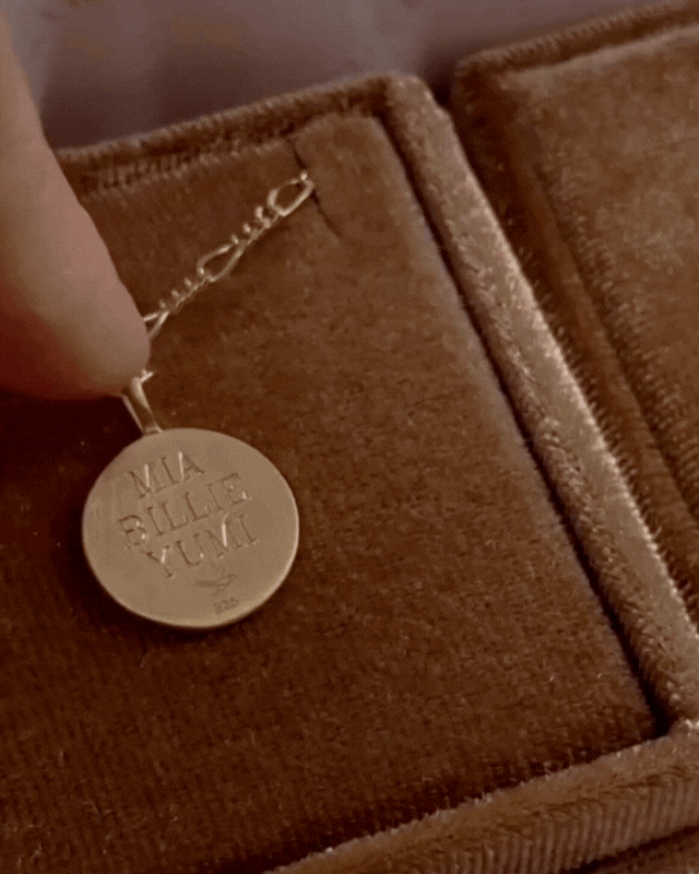 The signature necklace in gold displays the 3 names that are engraved on the back and a name on the front.