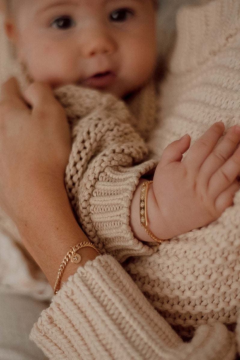 A tender image of a mother and child wearing Single Pearl Bracelet and Vintage Pearl Bracelet, symbolising love and connection by Bluebird Jewellery.