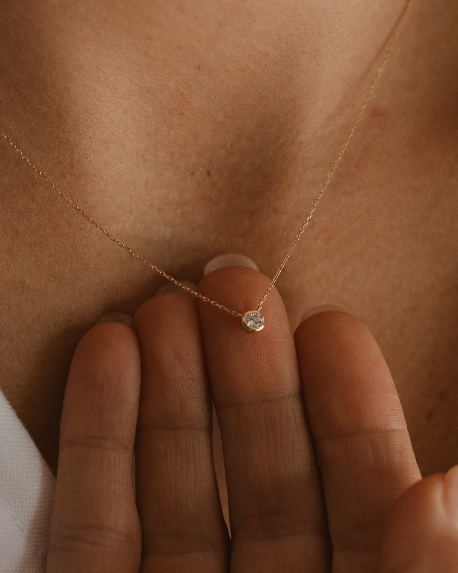 A close-up of the Lumé Necklace by Bluebird Jewellery, inspired by the French word for ‘light,’ crafted as a radiant symbol of warmth and kindness.