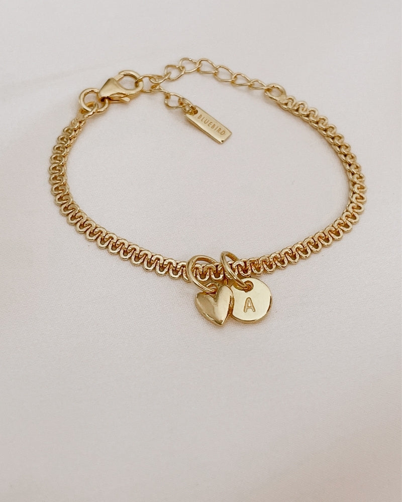 A close-up of The Lace Chain Bracelet adorned with a heart charm and personalised initial pendant, crafted as a meaningful keepsake piece by Bluebird Jewellery