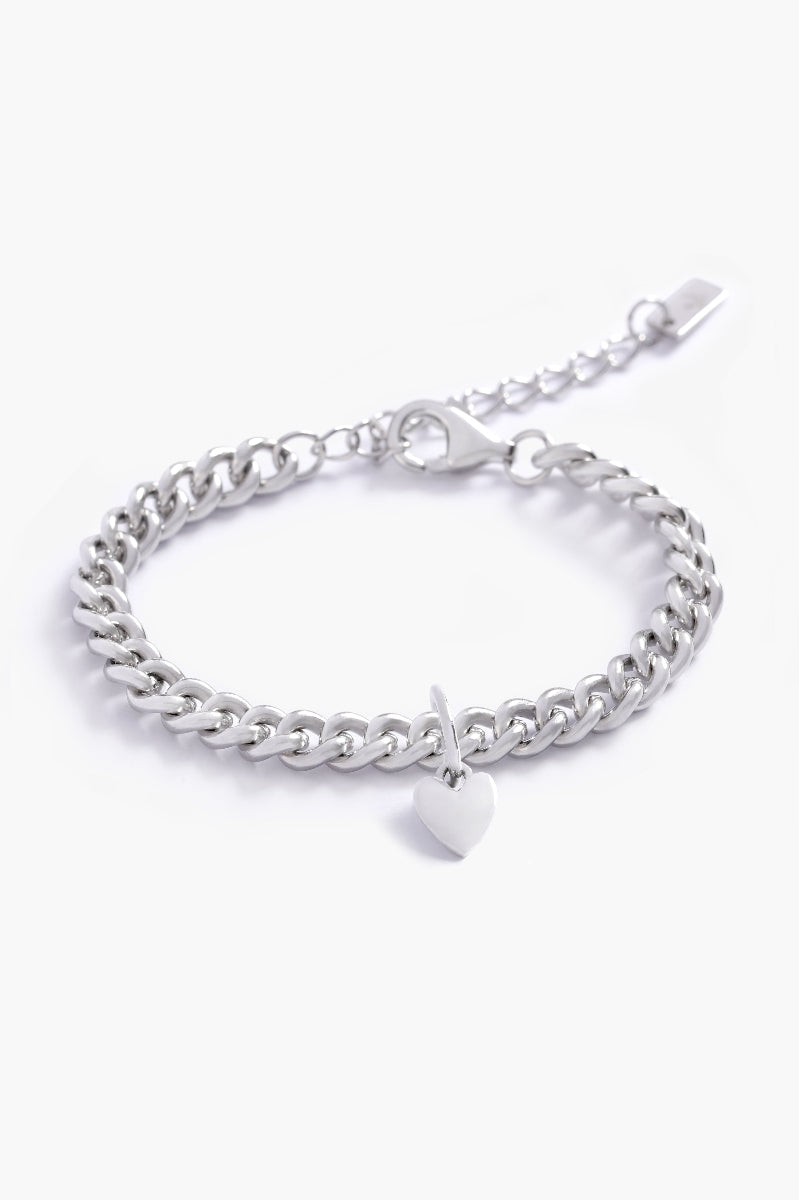 A minimalist silver bracelet with a heart charm, photographed on a white background to showcase its craftsmanship and simplicity by Bluebird Jewellery