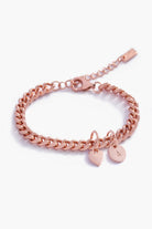 A rose gold Sweetheart Cuban Link Chain Bracelet adorned with a heart charm and engraved initial pendant, designed as a timeless personalised keepsake.