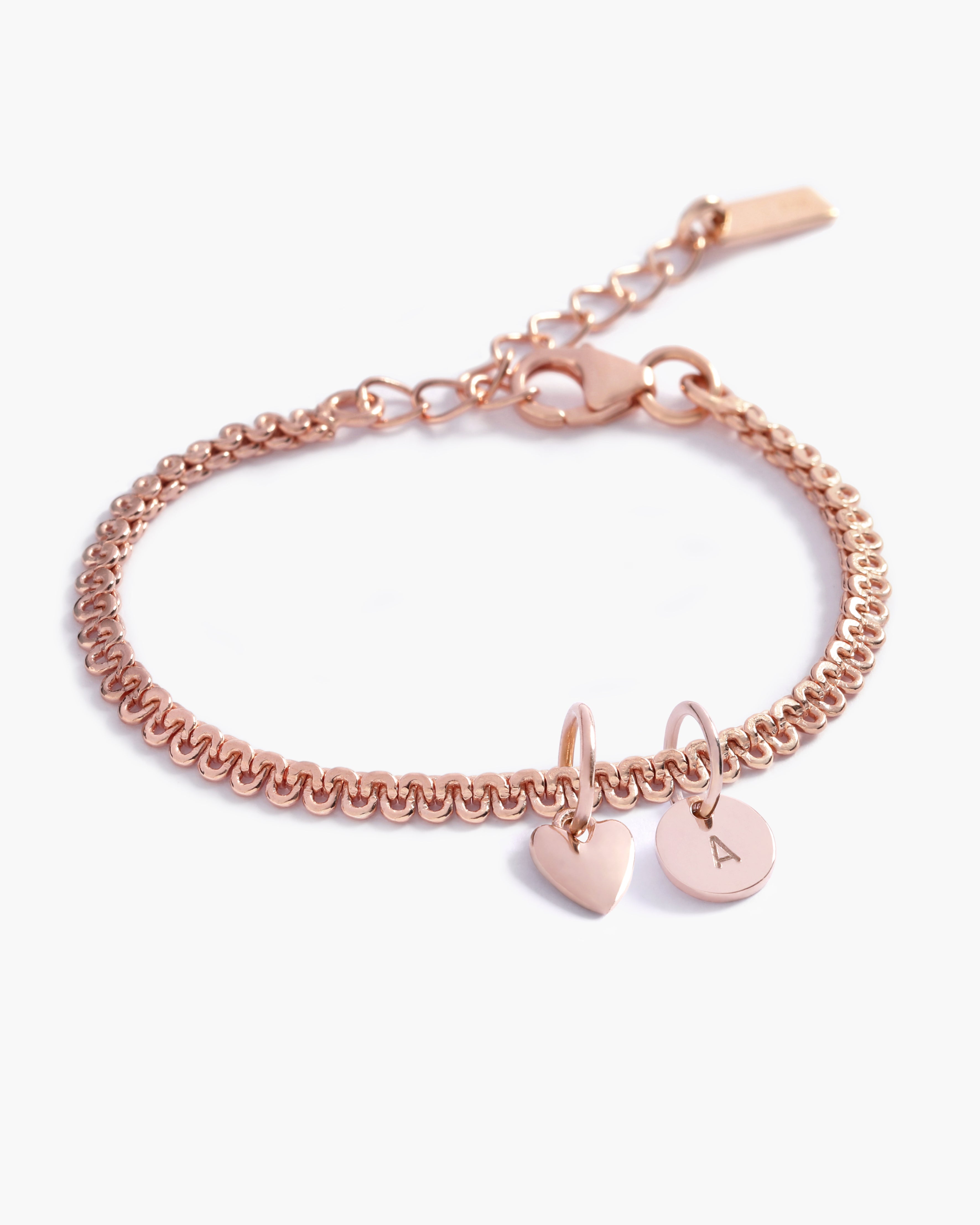 A close-up of a rose gold Lace Chain Bracelet adorned with a heart charm and personalised soild rose gold initial pendant, crafted as a meaningful keepsake piece by Bluebird Jewellery