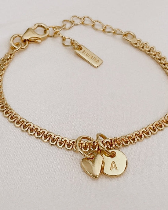A close-up of The Lace Chain anklet adorned with a heart charm and personalised initial pendant, crafted as a meaningful keepsake piece.