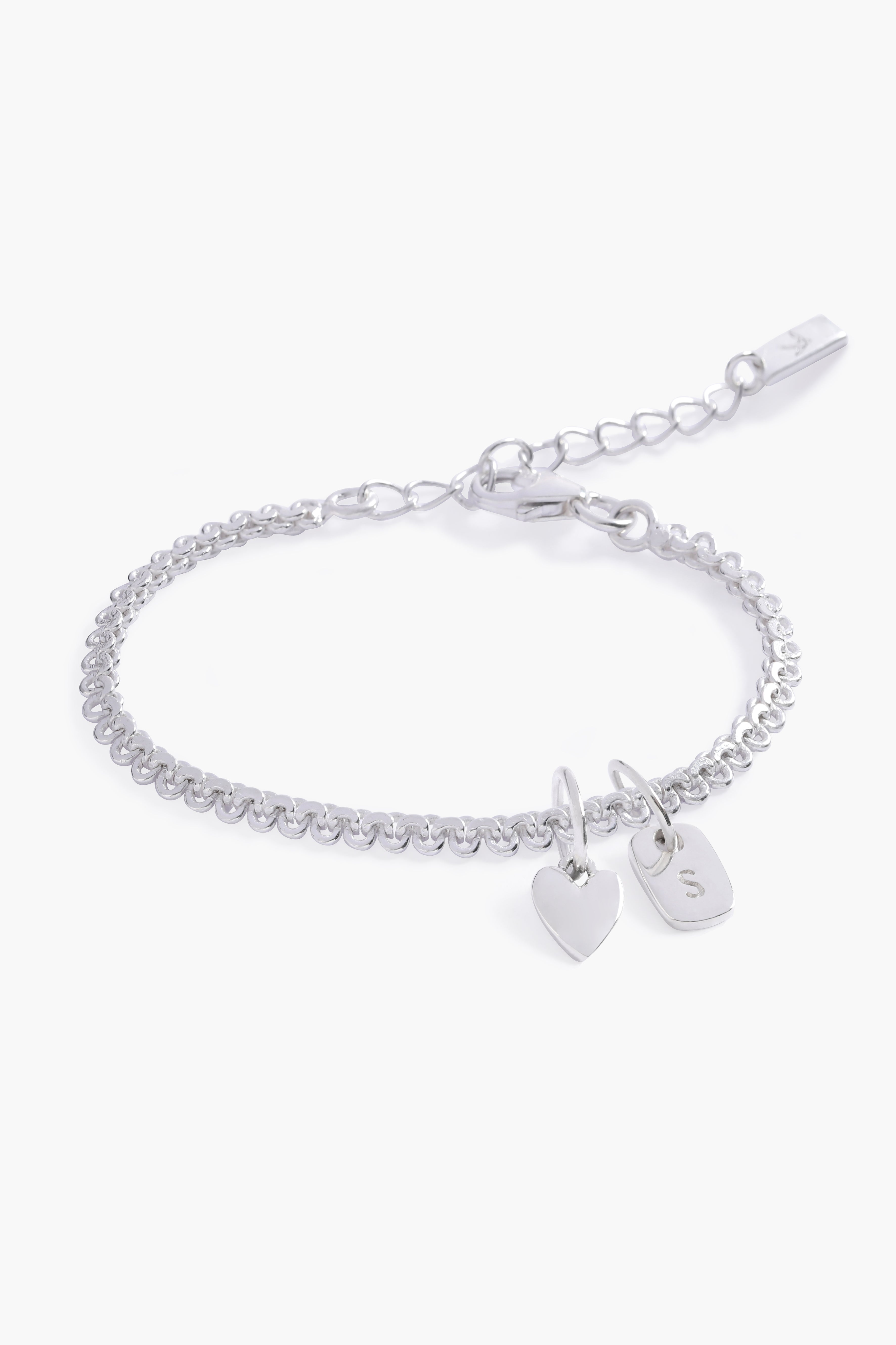 A delicate Sweetheart Lace Chain Bracelet featuring a silverheart charm and engraved rectangular letter pendant, crafted as a meaningful keepsake.