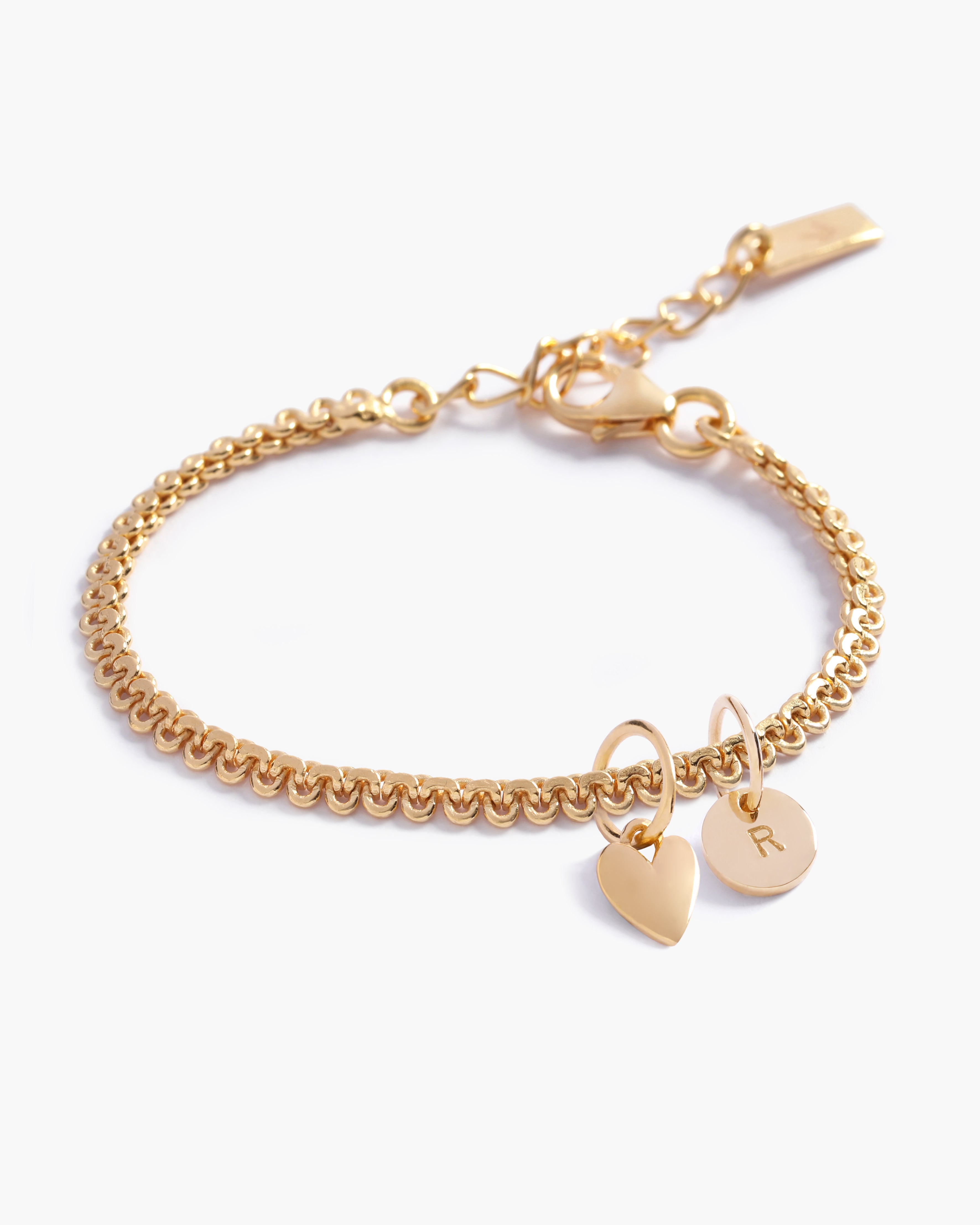 A personalised gold bracelet featuring a lace-like chain with a heart charm and solid gold letter pendant, designed as elegant fine jewellery for all ages by Bluebird Co