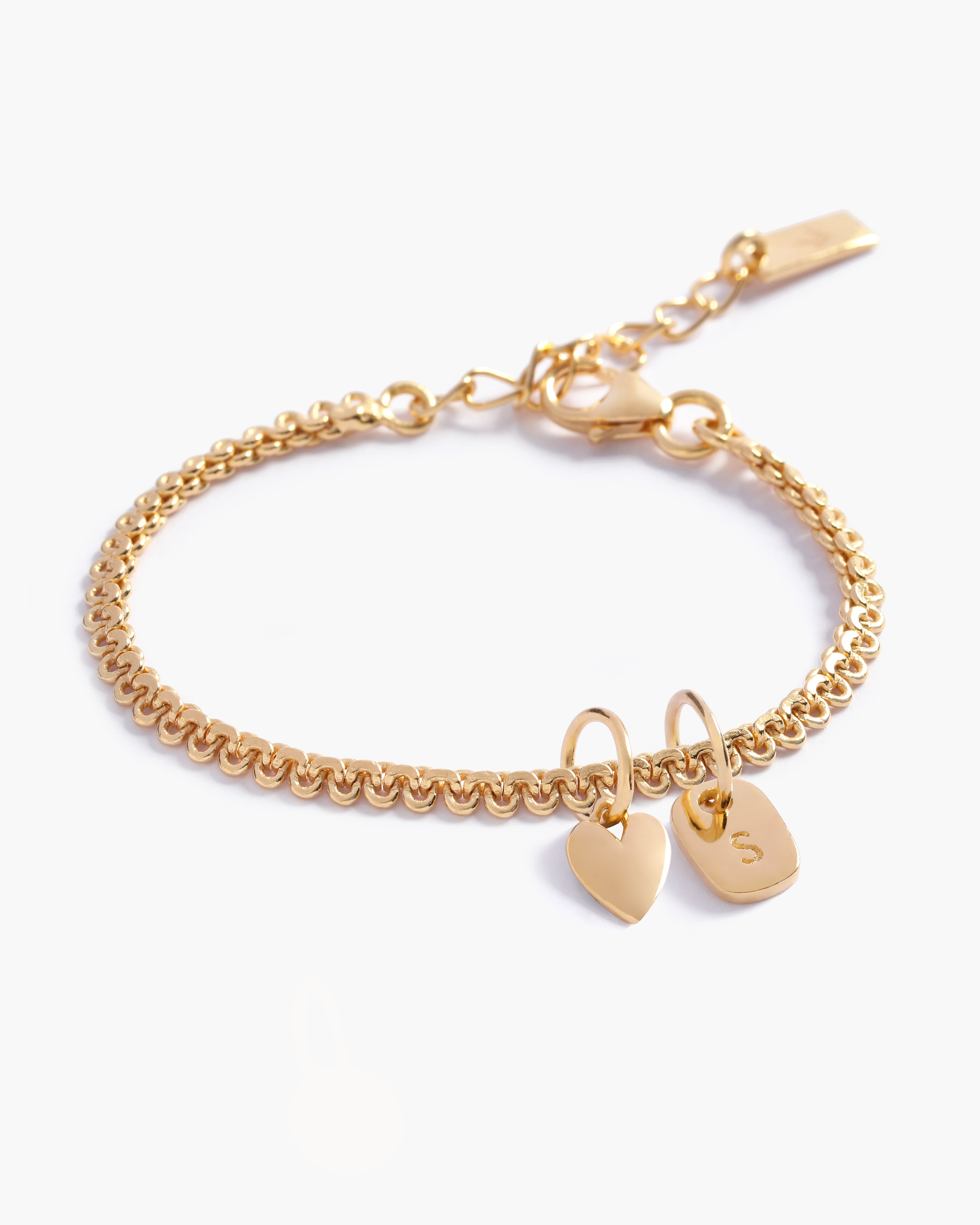 A personalised Lace Chain Bracelet featuring a heart charm and soild gold rectangular initial pendant, designed as an elegant fine jewellery gift for all ages by Bluebird Co