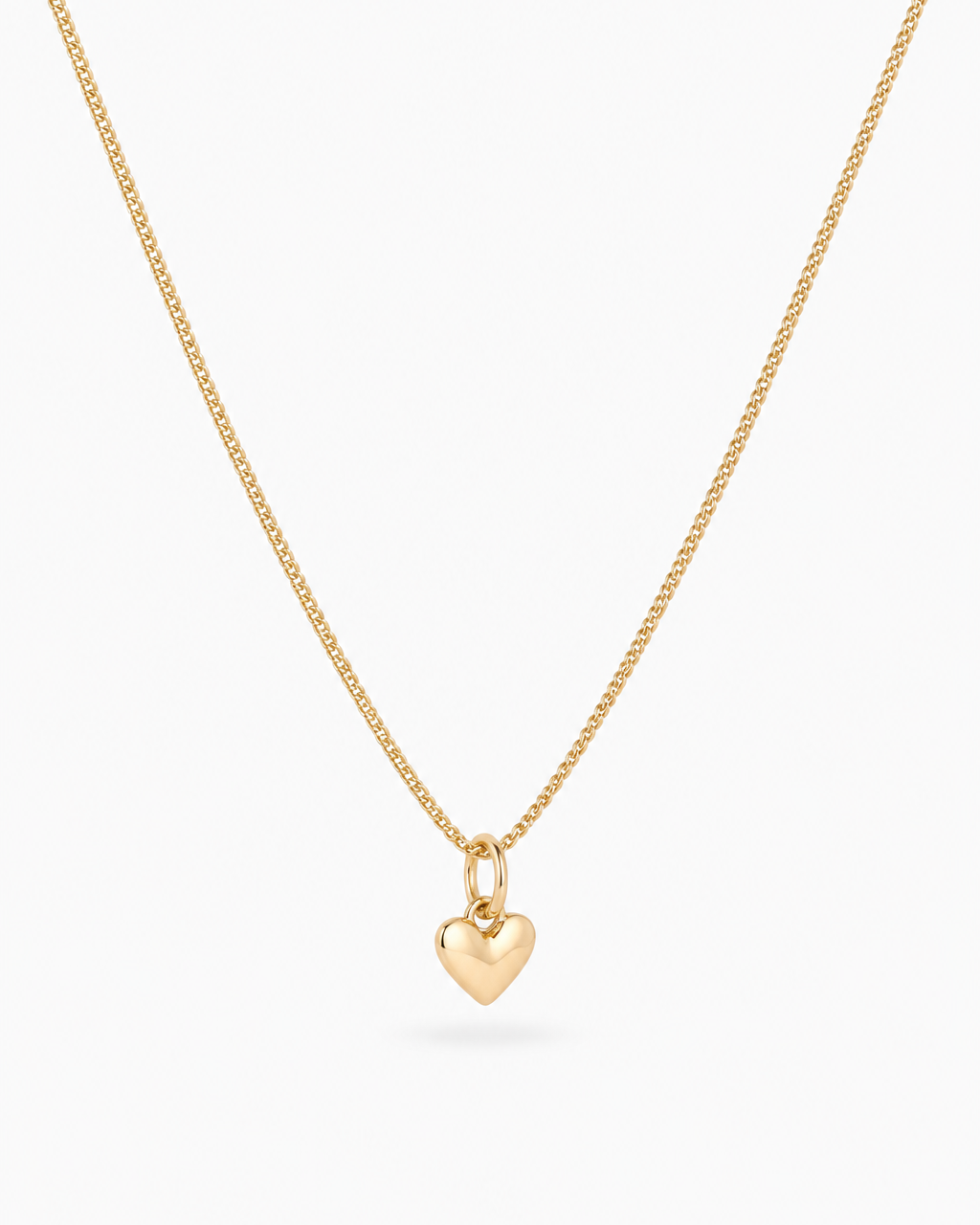 A delicate gold chain necklace with a small, polished gold heart pendant, displayed against a clean white background.