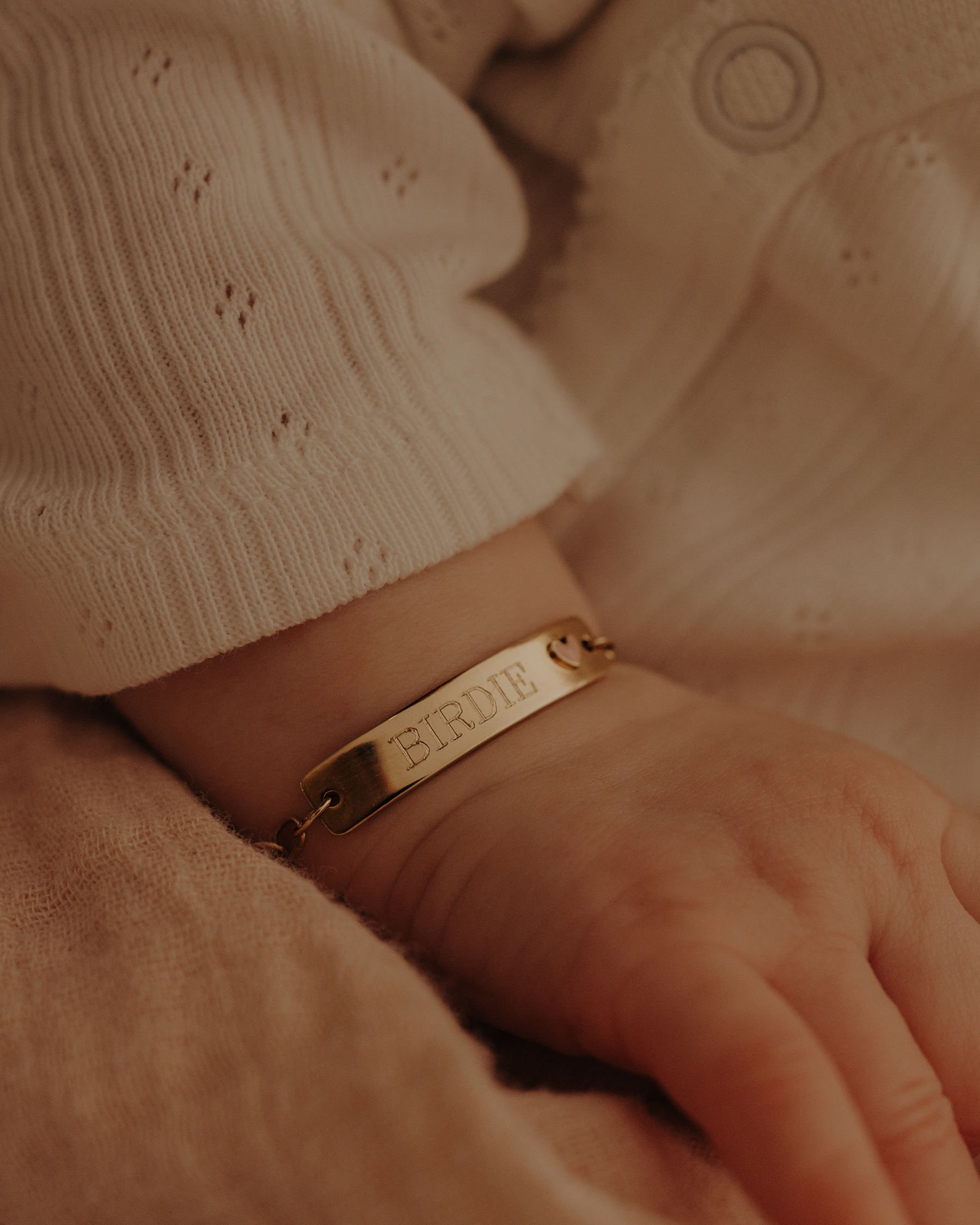 Baby girl wearing engraved 9ct solid gold Pink Darling Bracelet with pink heart