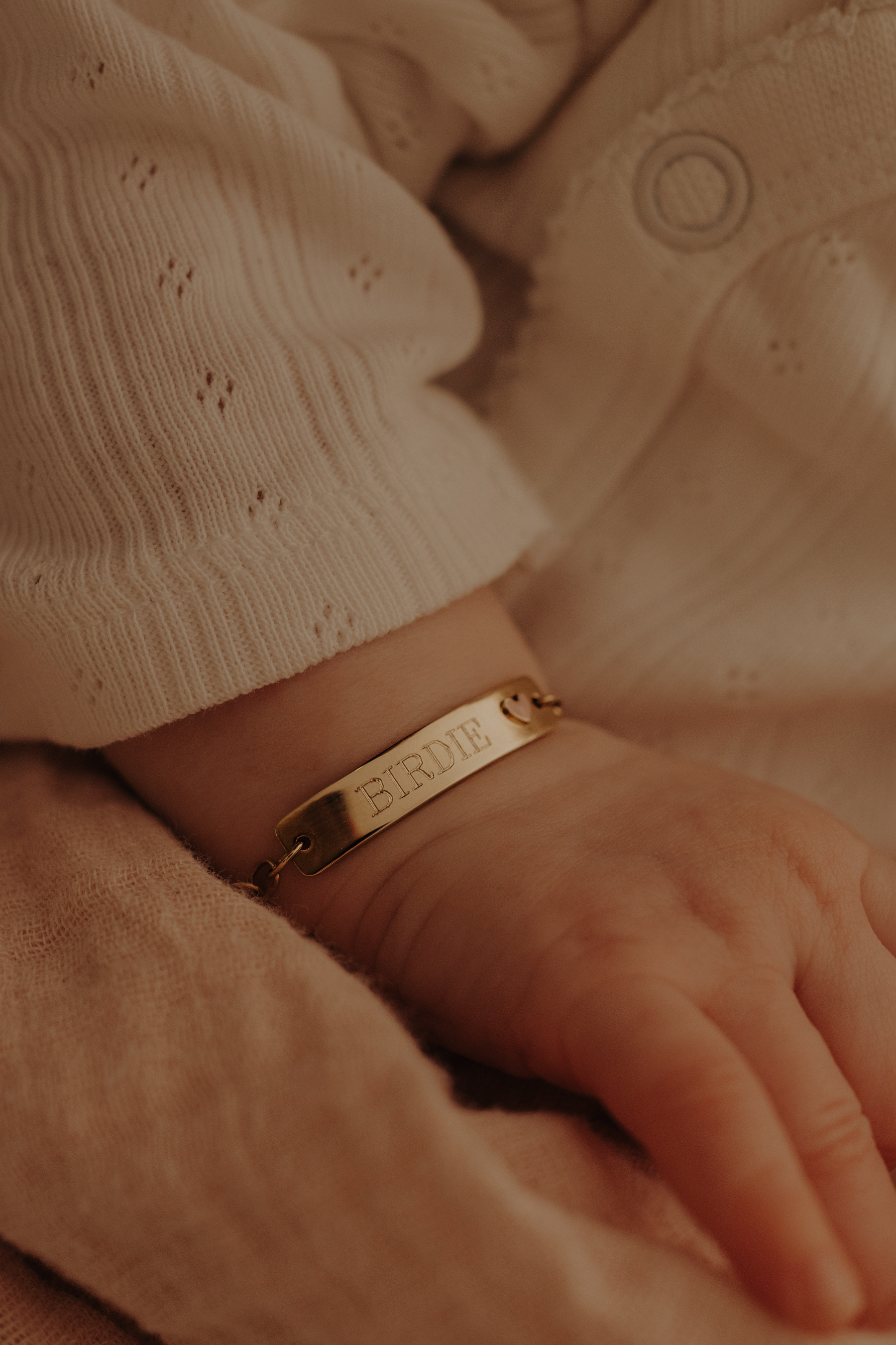 Baby girl wearing engraved 9ct solid gold Pink Darling Bracelet with pink heart