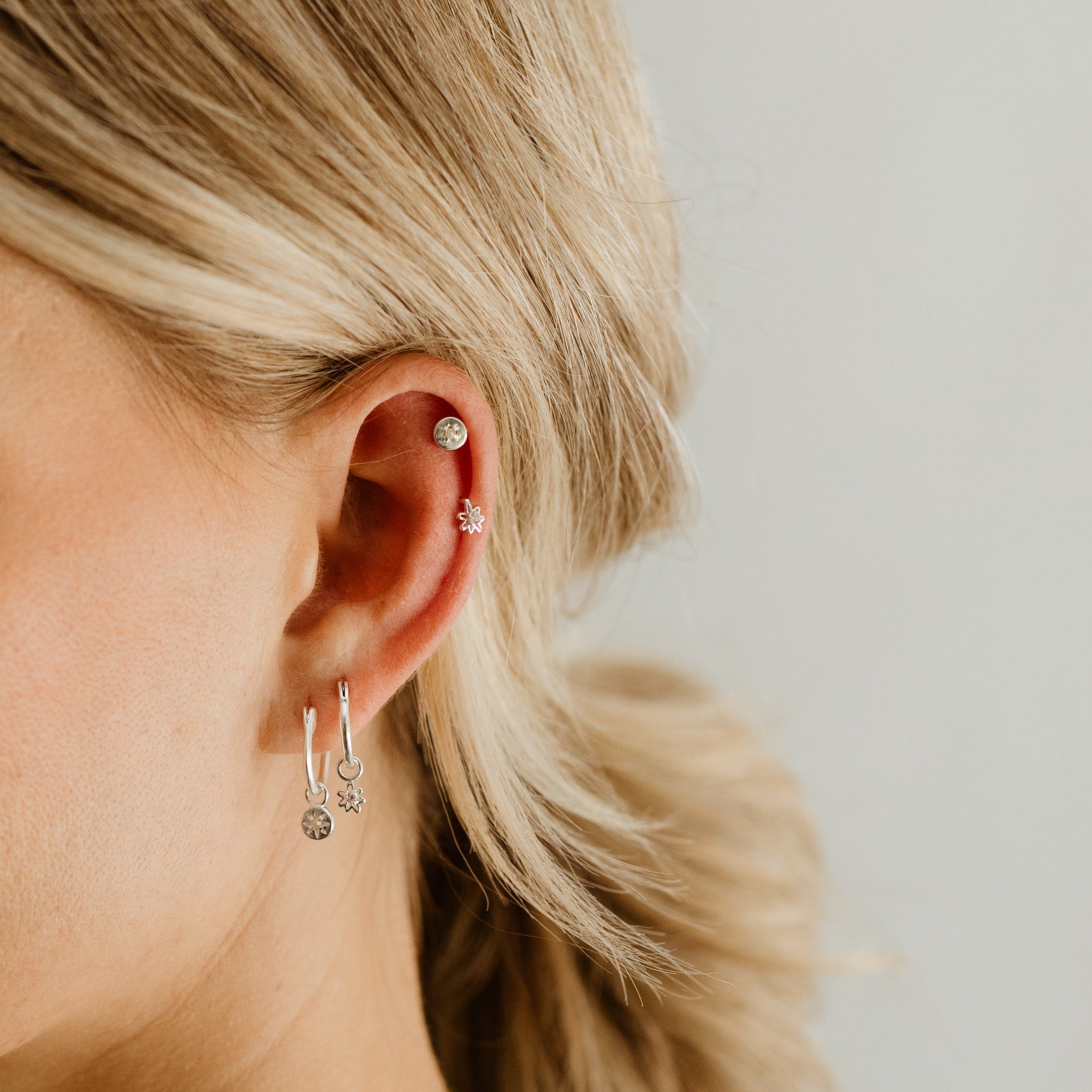 The Petite Daisy Stud is worn with the Petite Vintage Pearl Stud in the ear cartilage while the Vintage Pearl and Daisy Hoops are worn on the ear lobe.