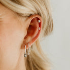 A Petite Shell Stud is worn high up on the ear cartilage on a model and is worn with other sterling silver Bluebird Co Earrings