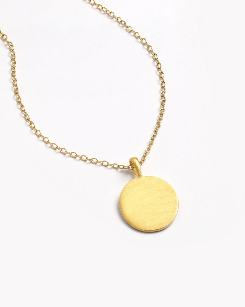 Front-facing view of blank petite gold disc necklace on fine chain.