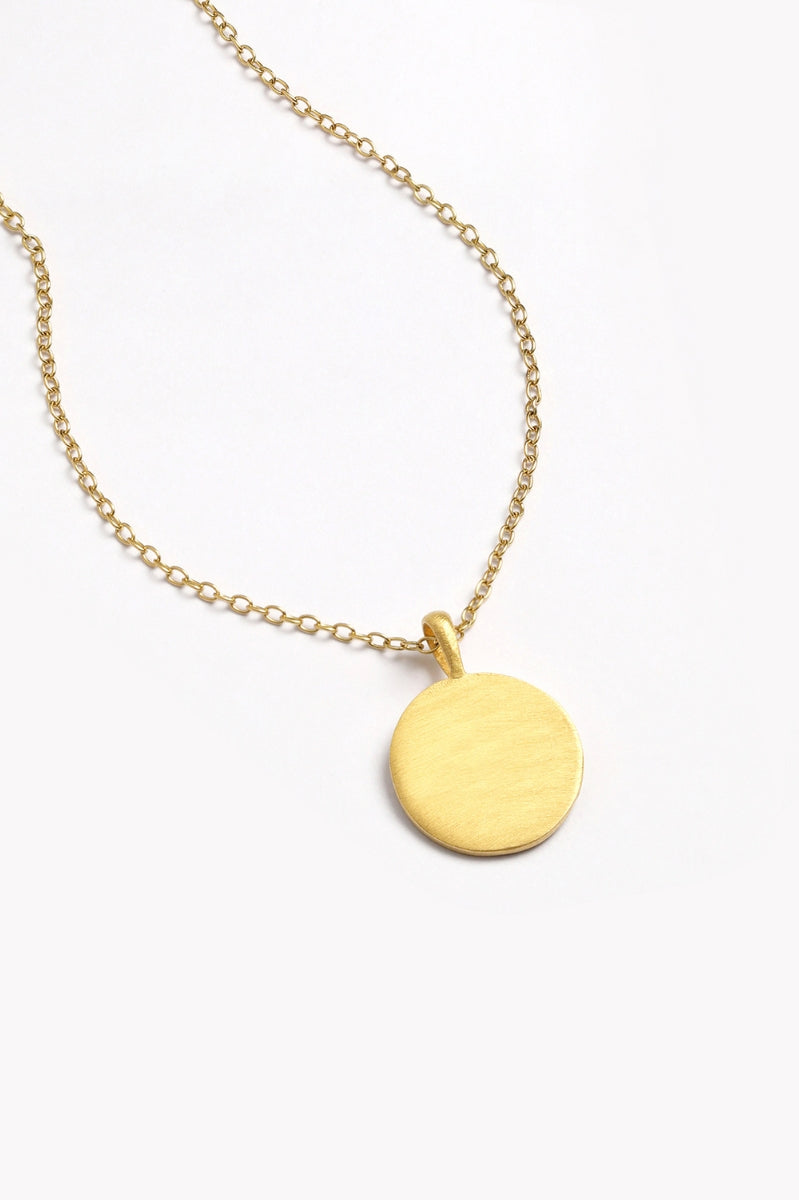 Front-facing view of blank petite gold disc necklace on fine chain.