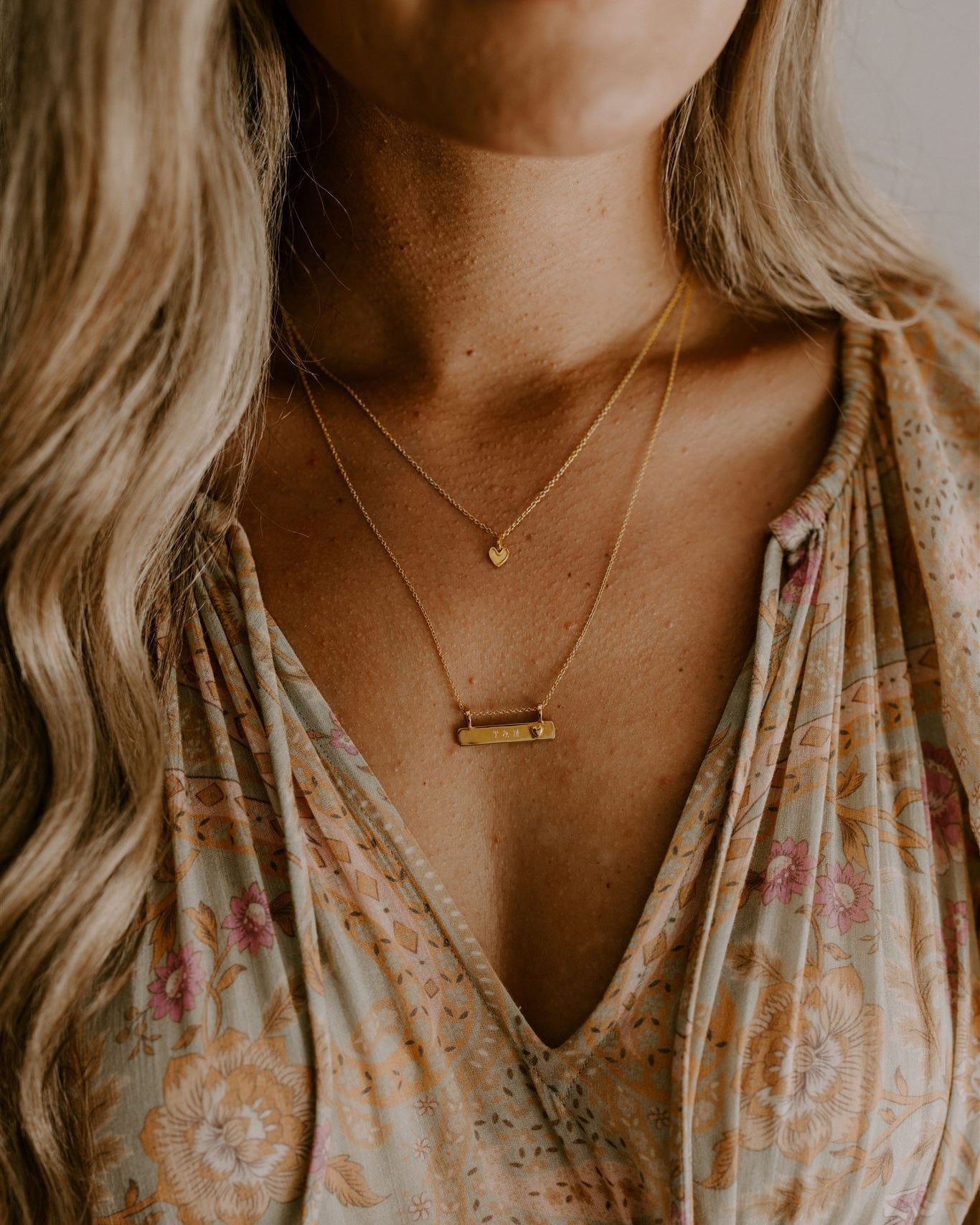 Engraved Darling Bar Necklace Gold layered with heart charm necklace on mother.
