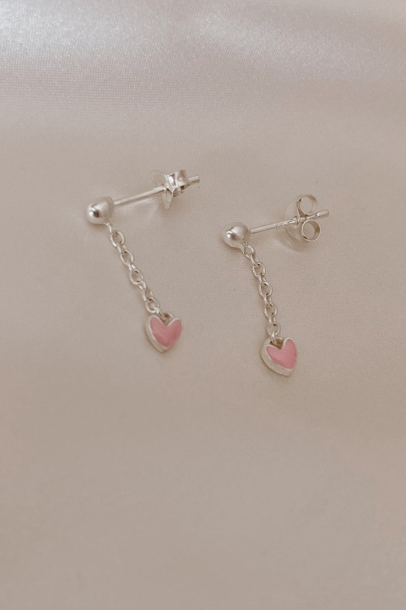 Flatlay of Darling Drop Sterling Silver Earrings with pink heart detail for everyday styling.