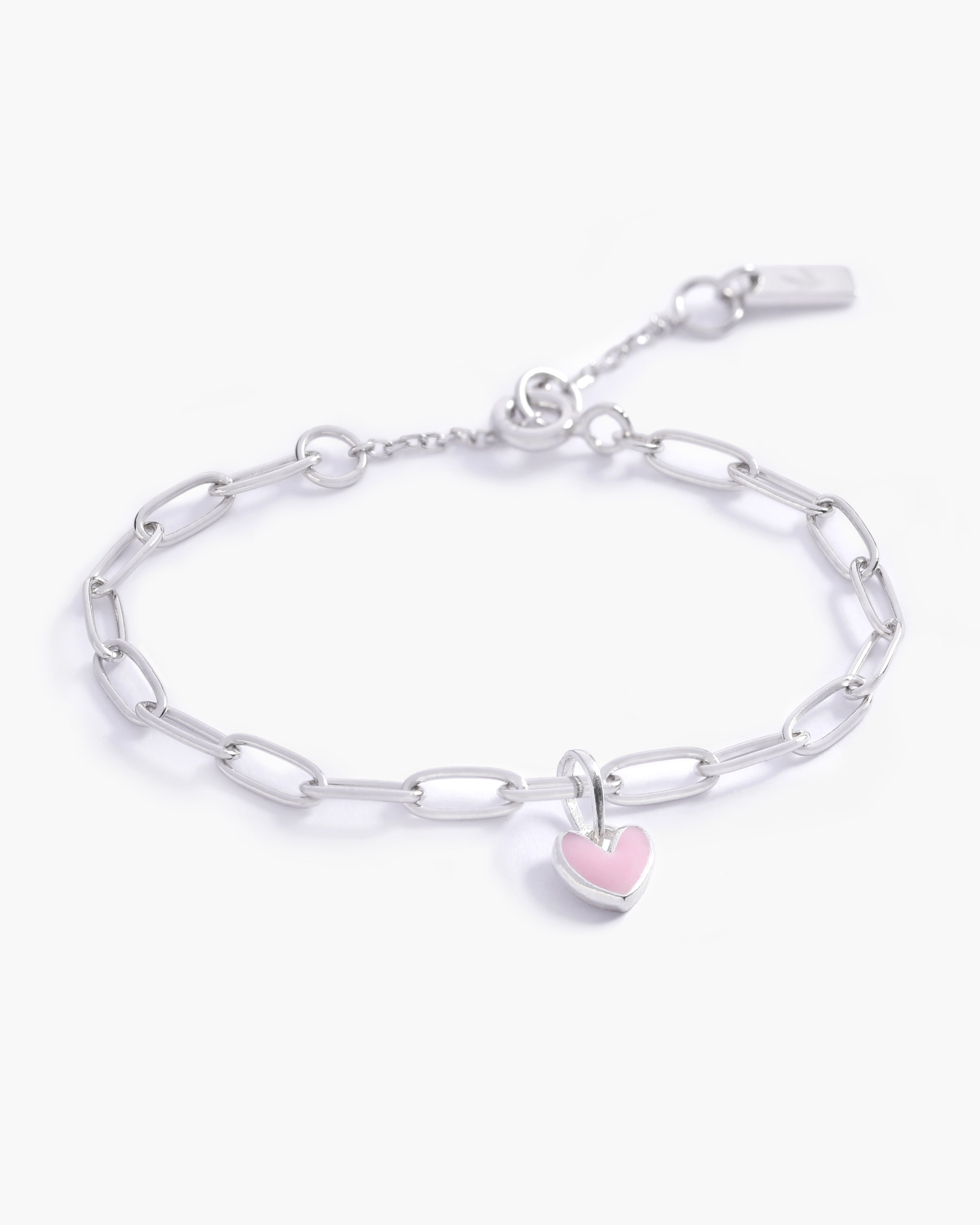 A close-up of a Darling Posie Bracelet by Bluebird Jewellery with a pink heart pendant on a sterling silver chain, designed in timeless fine jewellery style.
