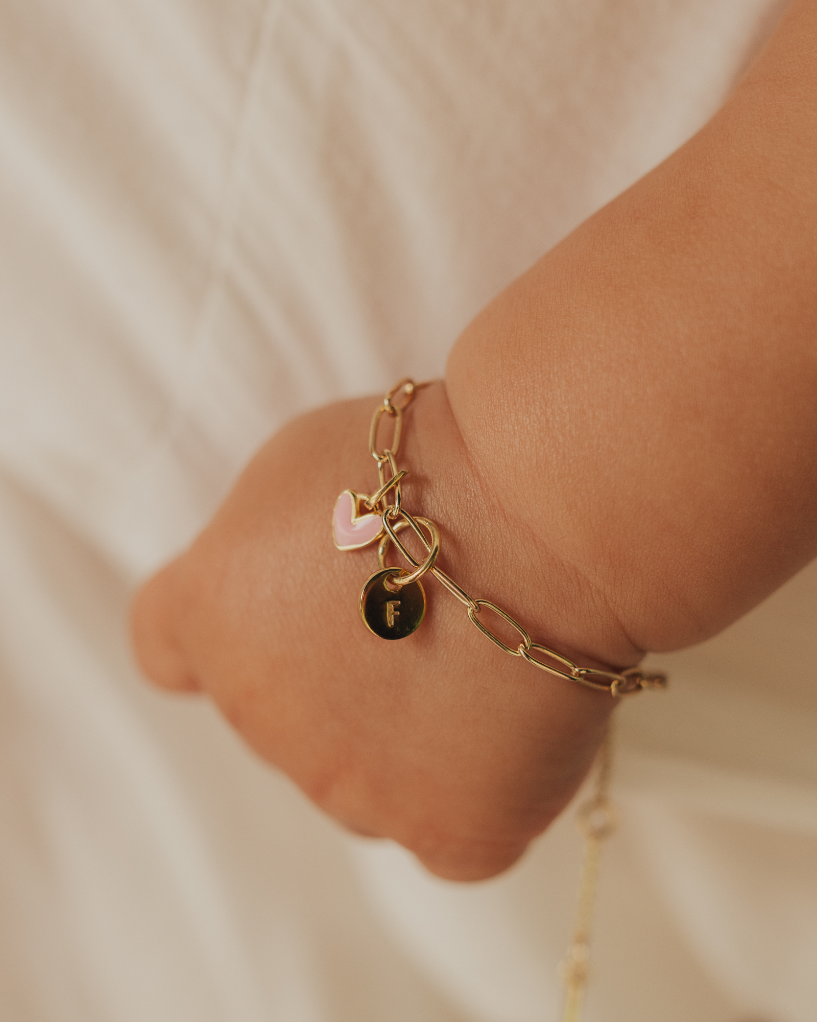 Baby and adult wearing Darling Posie Bracelets Gold with engraved charms, a meaningful family keepsake gift by Bluebird Jewellery.