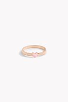 Rose gold ring with pink heart-shaped charm shown front on.