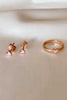 Pink heart rose gold ring displayed beside matching earrings.
