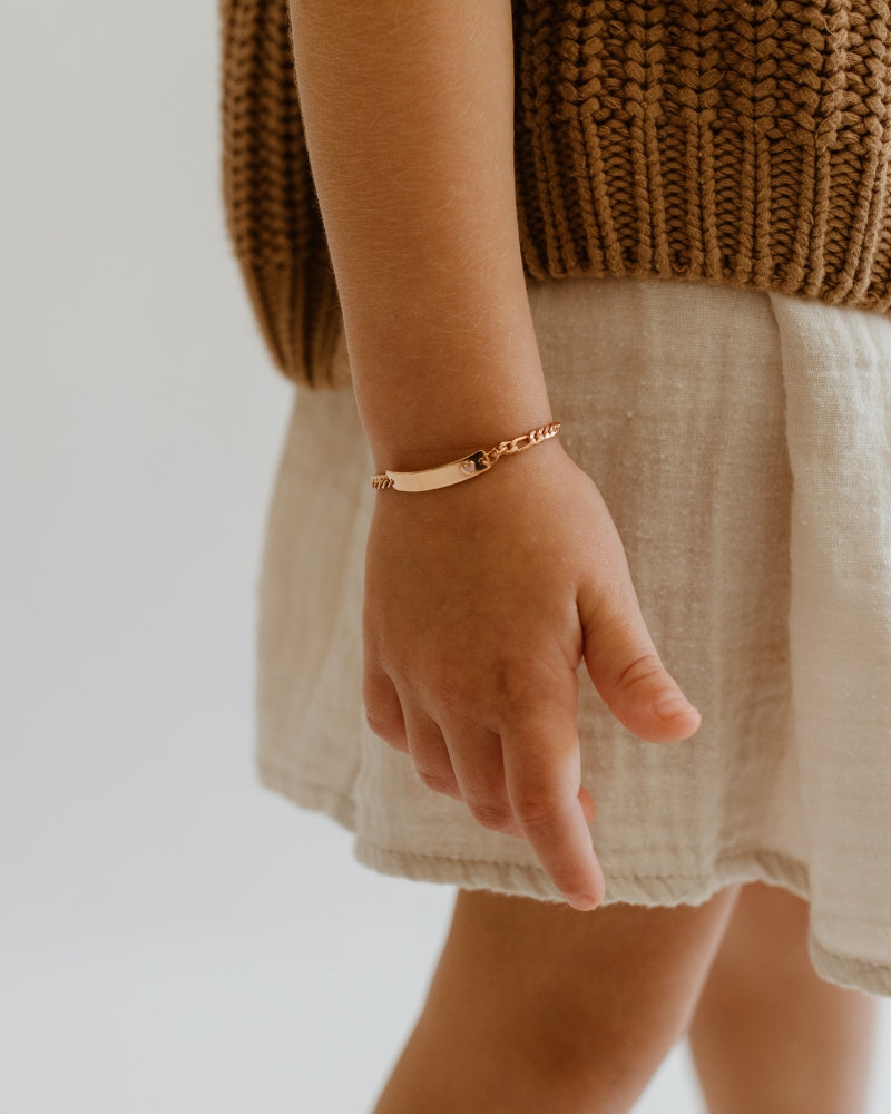 Child wearing the Darling Rose Gold Bracelet with a blank ID plate and classic curb chain design by Bluebird Jewellery.