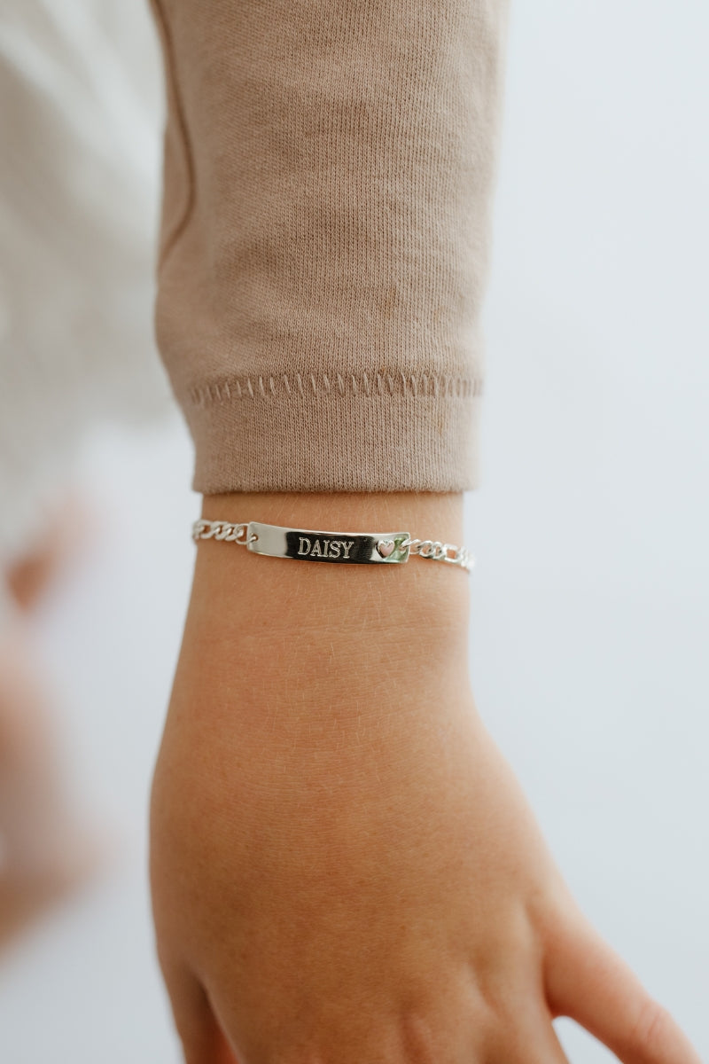 Child wearing engraved Pink Darling Silver Bracelet with pink heart—made for birthdays, keepsakes, or special occasions.