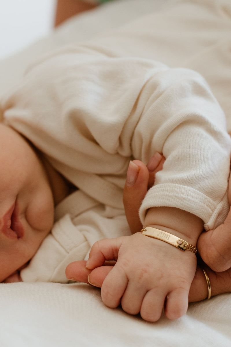 Baby wearing engraved Pink Darling Gold bracelet with heart—personalised gift for newborn milestones or keepsake moments.