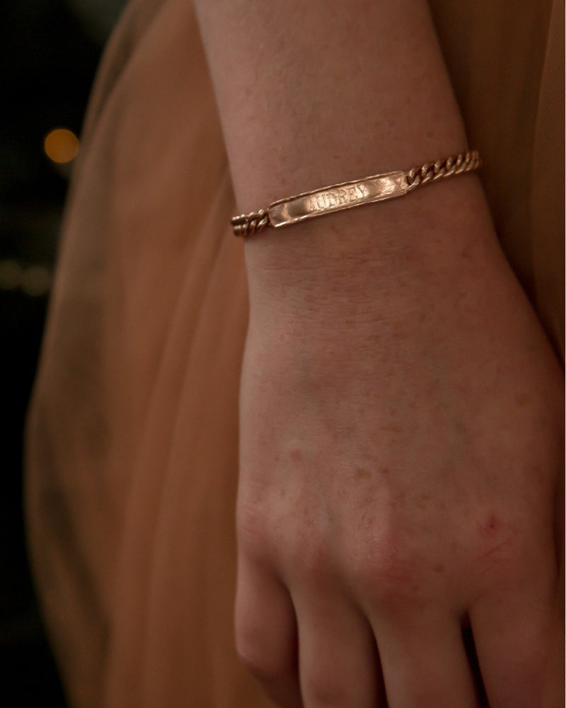 Signature bracelet in rose gold styled on wrist, featuring custom engraving and secure clasp for daily wear
