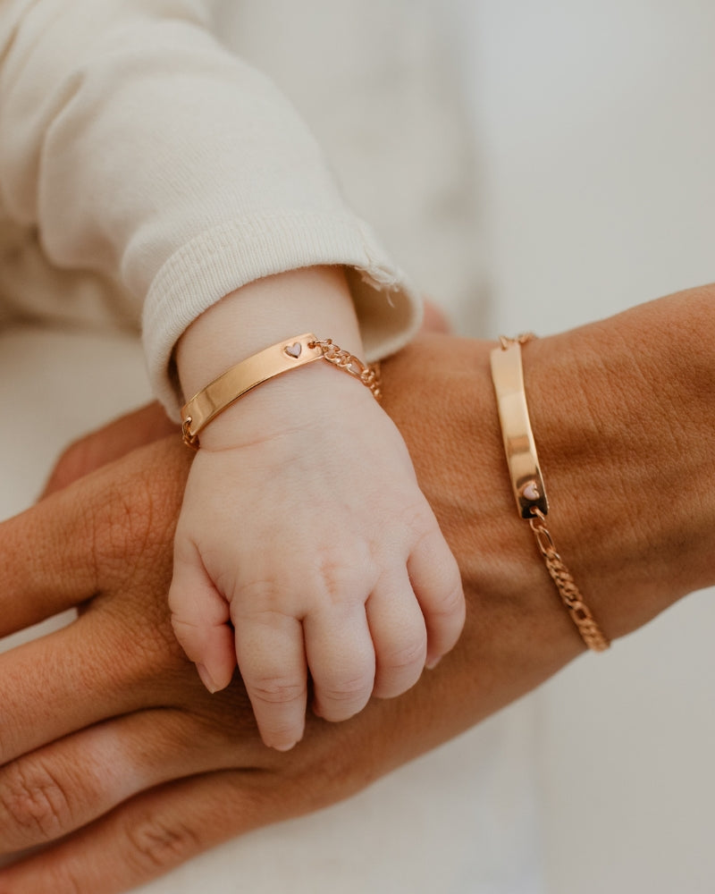 Baby and parent wearing matching Pink Darling Rose Gold bracelets—engraved jewellery to celebrate love, family, and milestones by Bluebird Jewellery.