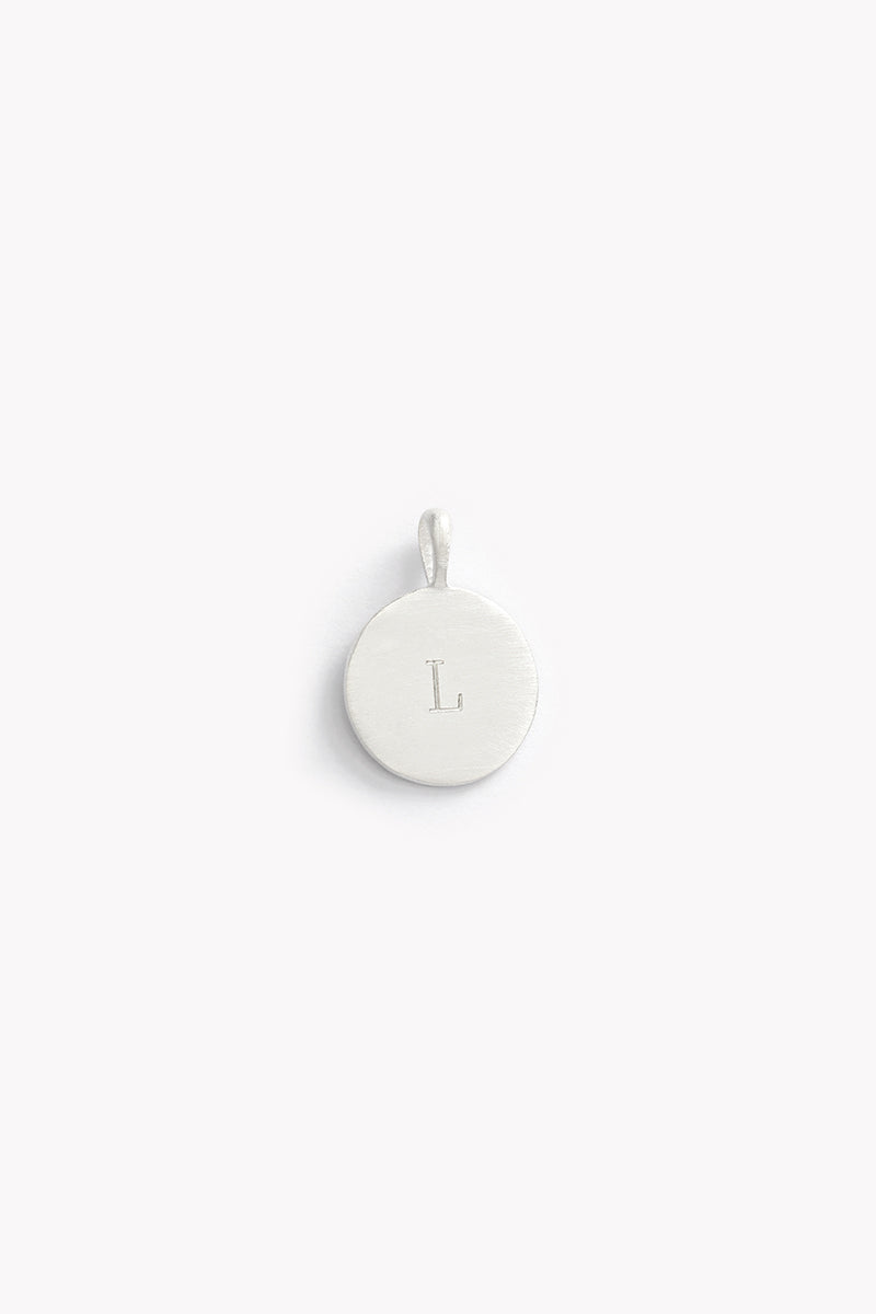 Single round silver pendant engraved with the letter L, from the Petite Signature Necklace Silver collection on white backdrop.