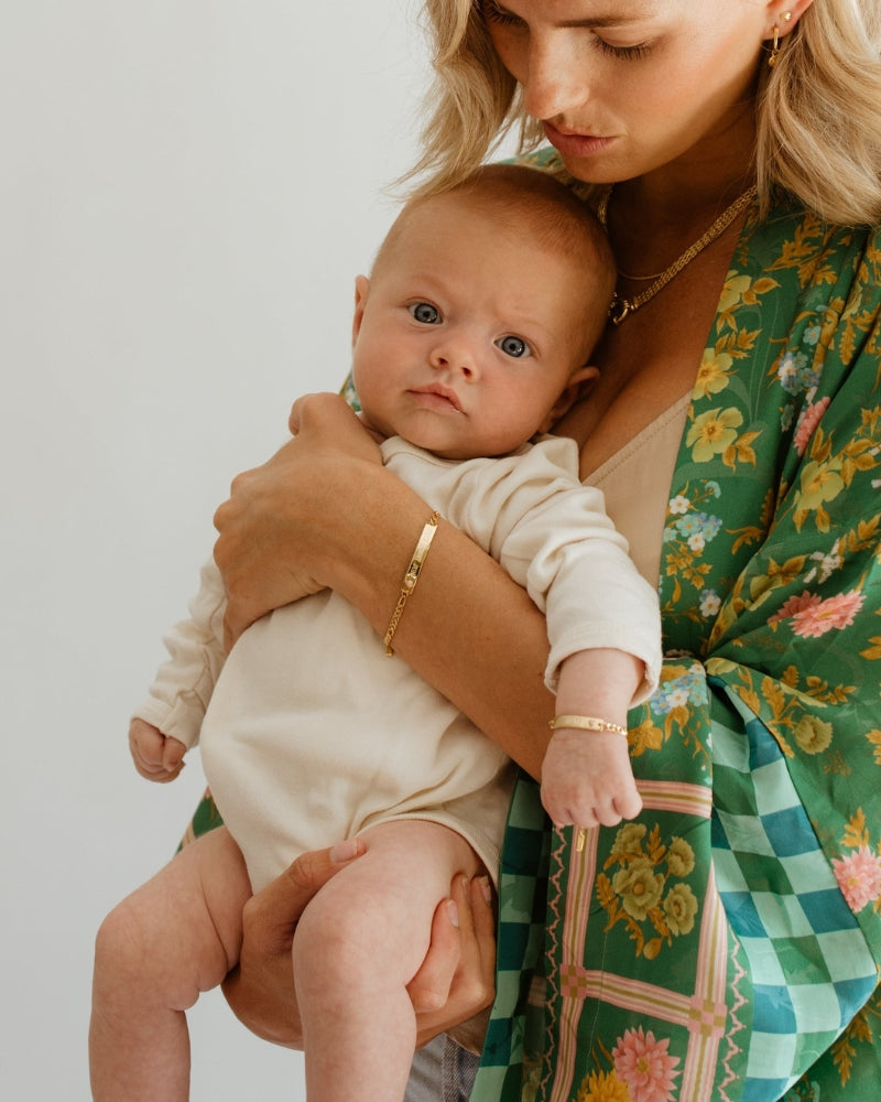 Mum and baby wear matching Pink Darling Gold bracelets—engraved personalised jewellery for bonding and gifting by Bluebird Jewellery.