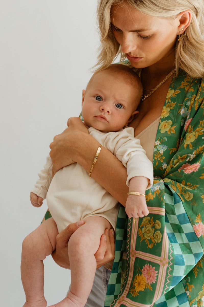 Mum and baby wear matching Pink Darling Gold bracelets—engraved personalised jewellery for bonding and gifting.