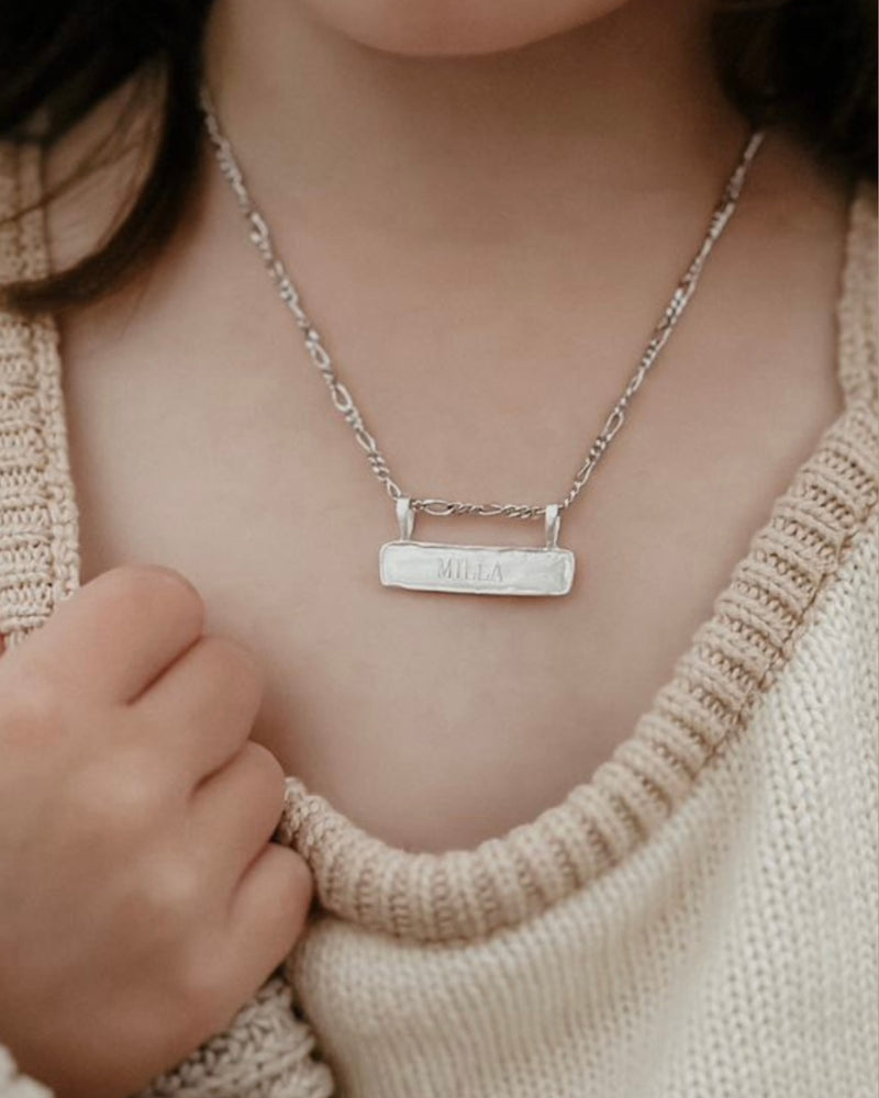Signature Bar Necklace Silver worn by a child, engraved with the name “MILLA”. A beautiful personalised necklace for kids and special moments.