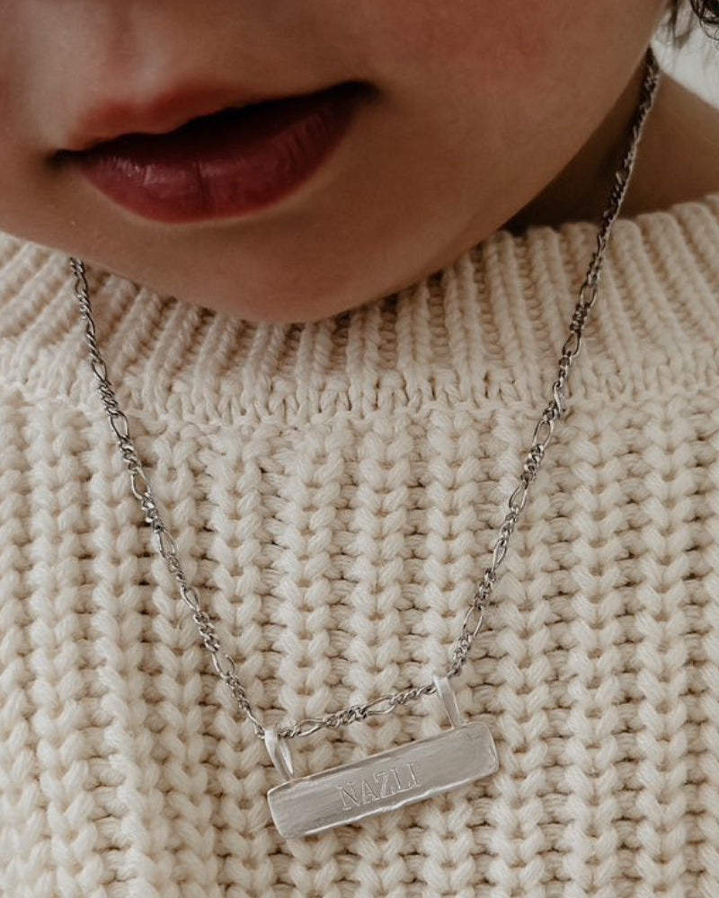 Signature Bar Necklace Silver engraved with “NAZLI” shown on a child’s chest. A cherished personalised necklace for everyday wear.