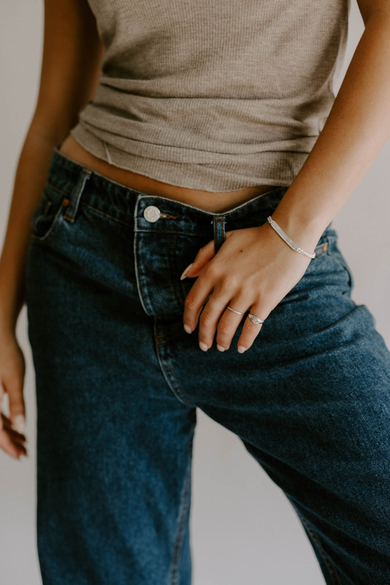 A woman wears the Adult length Signature Bracelet and it is paired beautifully with a Bluebird Signature Ring and Vintage Pearl Ring by Bluebird Jewellery.