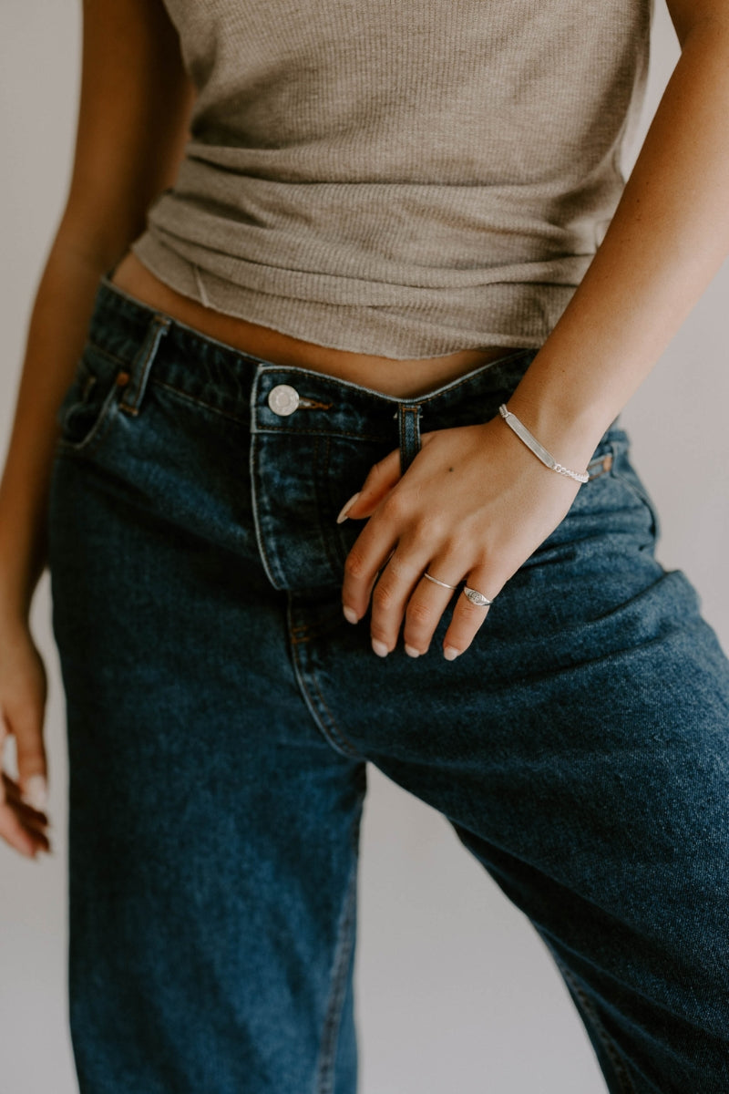A woman wears the Adult length Signature Bracelet and it is paired beautifully with a Bluebird Signature Ring and Vintage Pearl Ring by Bluebird Jewellery.