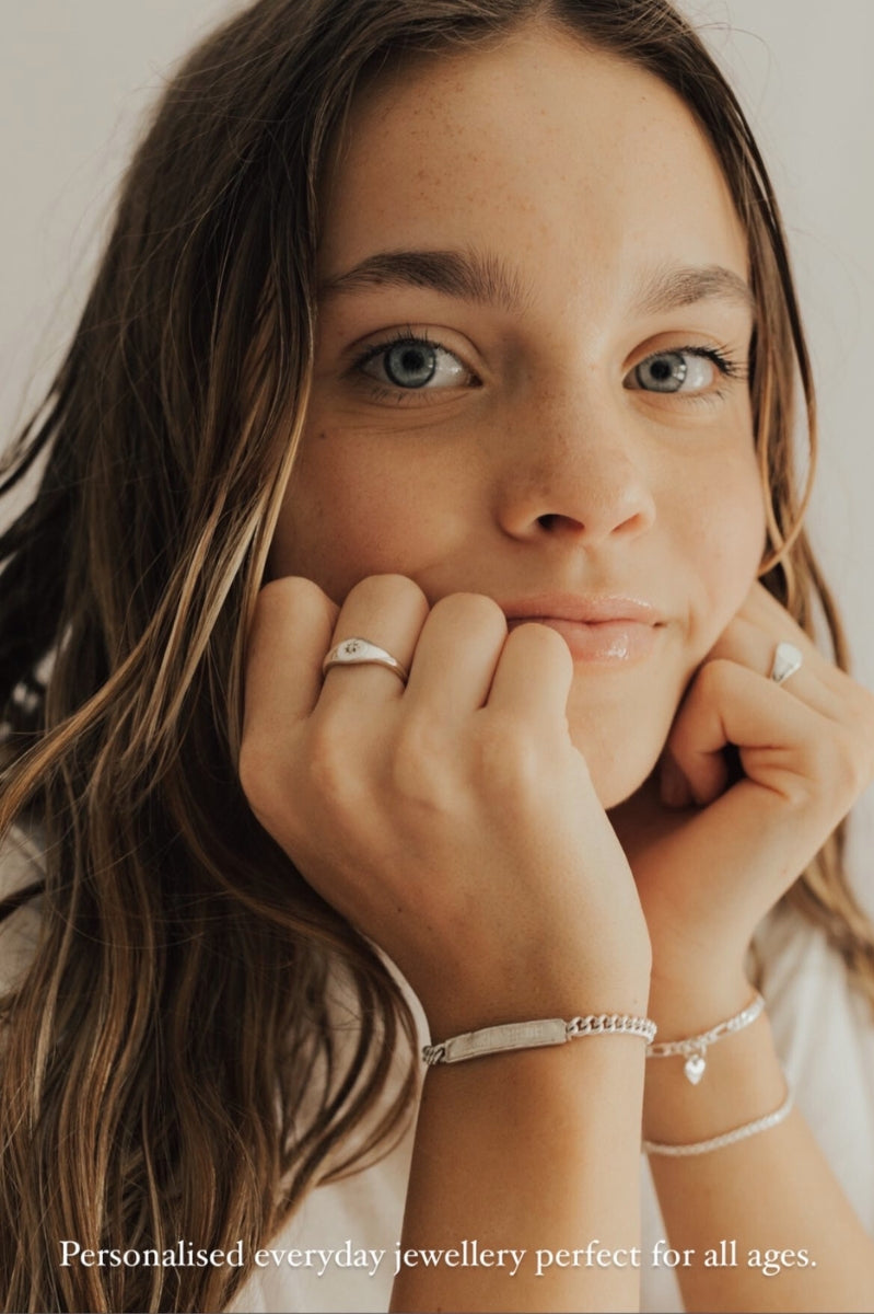 Teen girl wearing engraved signature bracelet silver and ring set, styled as everyday jewellery by Bluebird Co