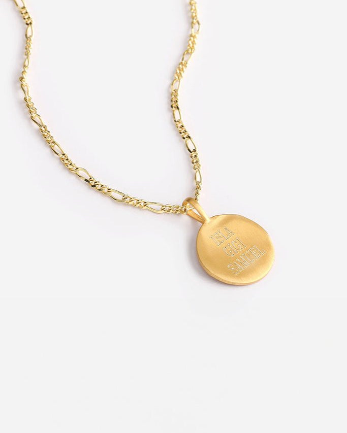 Engraved gold signature necklace with three names, displayed on Figaro chain for a bold, meaningful keepsake.